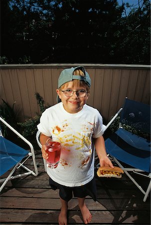 simsearch:700-00088823,k - Portrait de garçon malpropre détenant des hot-dogs et des boissons en plein air Photographie de stock - Rights-Managed, Code: 700-00066148