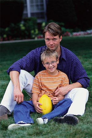 father child yard not illustration not business not vintage not 20s not 30s not 40s not 70s not 80s - Portrait of Father and Son Sitting Outdoors with Football Stock Photo - Rights-Managed, Code: 700-00067011