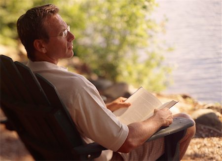 Man Sitting in Chair with Book Near Lake Stock Photo - Rights-Managed, Code: 700-00067114