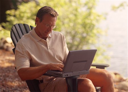 Man Sitting in Chair, Using Laptop Computer near Lake Stock Photo - Rights-Managed, Code: 700-00067112