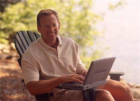 Portrait of Man Sitting in Chair With Laptop Computer near Lake Stock Photo - Rights-Managed, Code: 700-00067113