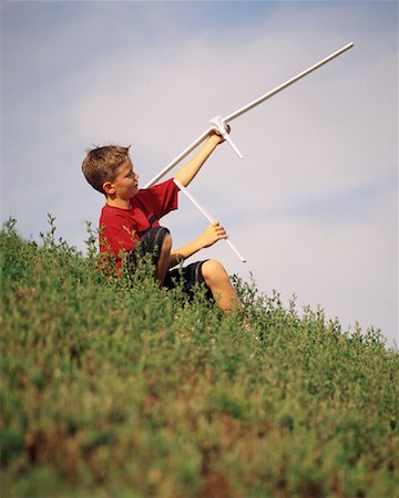 Boy Sitting on Hill with Toy Airplane Stock Photo - Rights-Managed, Code: 700-00067426