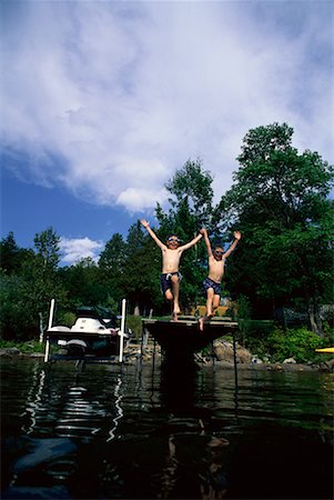 Two Boys Jumping into Lake from Dock Stock Photo - Rights-Managed, Code: 700-00067580