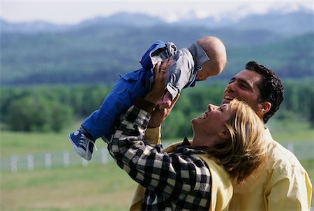 Mother and Father Lifting Baby in Air Outdoors Stock Photo - Rights-Managed, Code: 700-00067961