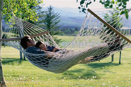 Father and Son Relaxing in Hammock Outdoors Foto de stock - Con derechos protegidos, Código: 700-00068118