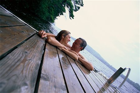 secluded lake woman - Mature Couple in Lake, Leaning On Dock, Talking Stock Photo - Rights-Managed, Code: 700-00068245