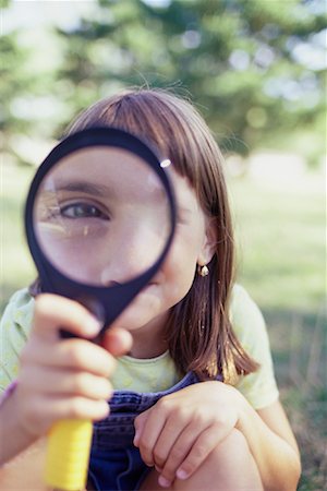 Portrait of Girl Looking through Magnifying Glass Outdoors Foto de stock - Direito Controlado, Número: 700-00069330