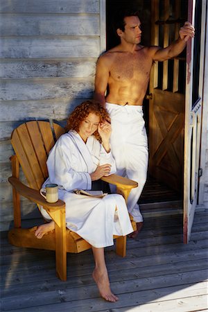 Woman in Bathrobe, in Chair on Porch, Holding Hands with Man in Doorway Stock Photo - Rights-Managed, Code: 700-00069373