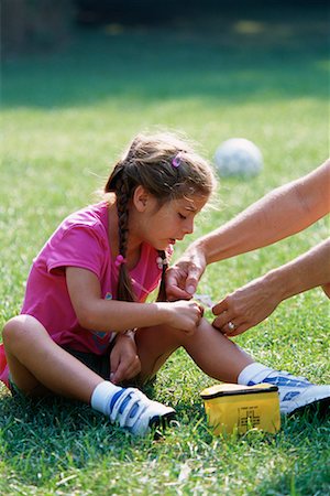 Hands Putting Bandage on Girls Knee Outdoors, Toronto, Ontario Canada Stock Photo - Rights-Managed, Code: 700-00069522