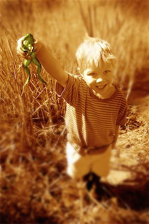 Portrait of Boy Standing in Field Of Tall Grass, Holding Frog Stock Photo - Rights-Managed, Code: 700-00069687