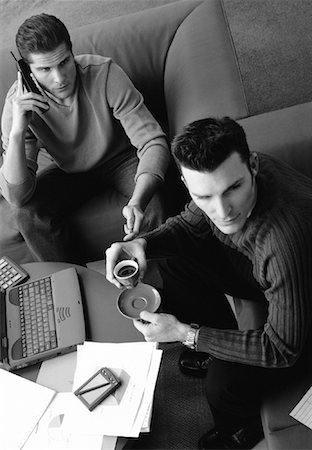 Two Men Sitting on Sofa with Laptop, Phone and Cup Stock Photo - Rights-Managed, Code: 700-00060242