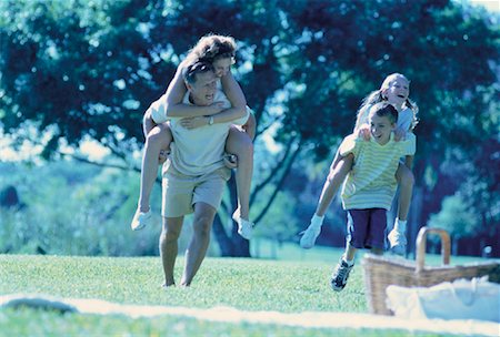 family picnics play - Father and Son Carrying Mother And Daughter on Backs Outdoors Stock Photo - Rights-Managed, Code: 700-00060354