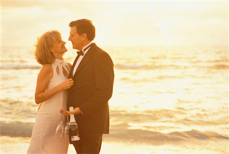 Mature Couple in Formal Wear with Champagne and Glasses on Beach Stock Photo - Rights-Managed, Code: 700-00060764