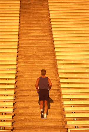 superar obstáculos - Back View of Mature Man Running Up Stadium Steps Foto de stock - Con derechos protegidos, Código: 700-00060792