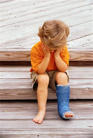 Boy with Cast on Leg Sitting on Steps Looking Down Fotografie stock - Rights-Managed, Codice: 700-00061281