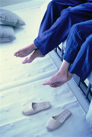 Couple's Legs Hanging over Foot Of Bed Stock Photo - Rights-Managed, Code: 700-00061431