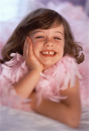 Portrait of Girl Lying on Bed Wearing Pink Boa Stock Photo - Rights-Managed, Code: 700-00061476