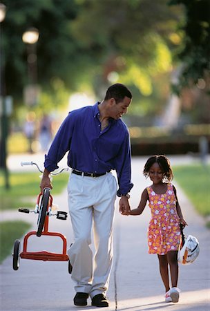 Father Carrying Tricycle, Holding Hands with Daughter on Street Stock Photo - Rights-Managed, Code: 700-00061823