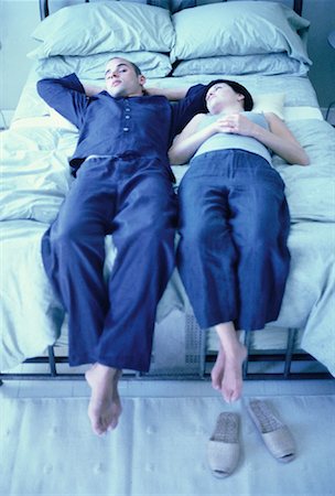 simsearch:700-00061557,k - Couple reposant sur le lit avec les jambes pendre au-dessus de bord Photographie de stock - Rights-Managed, Code: 700-00061875