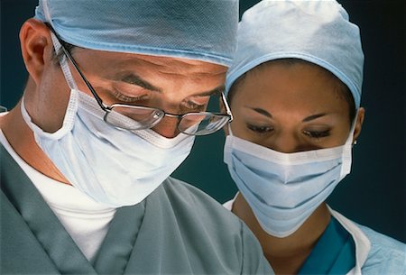 doctor with cap and mask - Male and Female Surgeons Wearing Surgical Masks, Looking Down Stock Photo - Rights-Managed, Code: 700-00062076