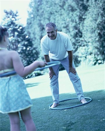 Grandfather and Granddaughter Using Hula Hoops Outdoors Stock Photo - Rights-Managed, Code: 700-00062366