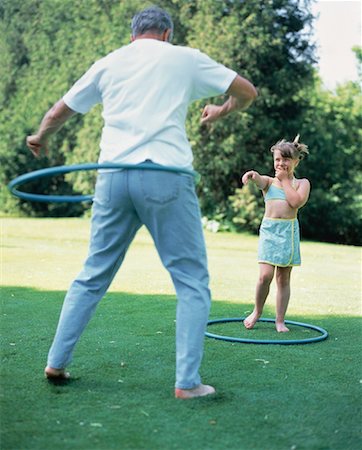 seniors photography girls playing sports - Grandfather and Granddaughter Using Hula Hoops Outdoors Stock Photo - Rights-Managed, Code: 700-00062368