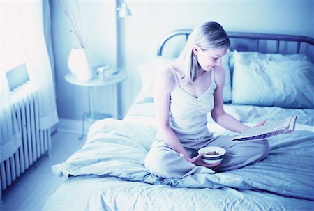 simsearch:700-00062758,k - Woman Sitting on Bed Reading Newspaper, Holding Bowl of Cereal Stock Photo - Rights-Managed, Code: 700-00062758