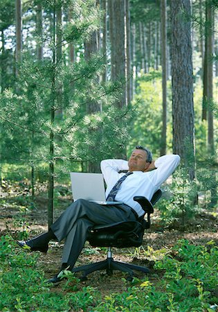 Businessman Relaxing in Chair With Laptop Computer in Forest Stock Photo - Rights-Managed, Code: 700-00062984