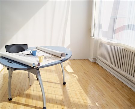 Blueprints, Eyeglasses and Mugs On Table in Empty Room Stock Photo - Rights-Managed, Code: 700-00063399