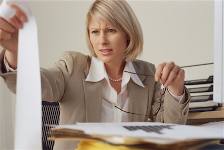 female banker (owner or executive) - Businesswoman Sitting at Desk Looking at Adding Machine Tape Stock Photo - Rights-Managed, Code: 700-00074074