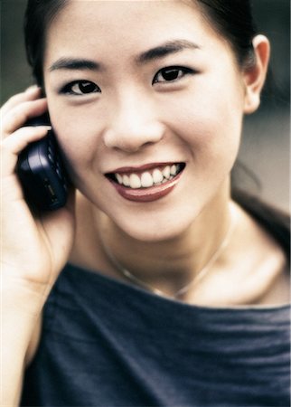 simsearch:700-00917701,k - POrtrait de femme en utilisant un téléphone cellulaire, souriant Photographie de stock - Rights-Managed, Code: 700-00074242