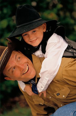 Portrait of Father with Son on Back, Wearing Cowboy Hats Outdoors Stock Photo - Rights-Managed, Code: 700-00074662