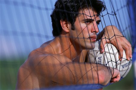 Man Leaning on Net, Holding Volleyball Outdoors Stock Photo - Rights-Managed, Code: 700-00074750