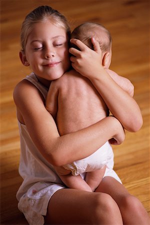 sister hugs baby - Portrait of Girl Sitting on Floor Holding Baby Stock Photo - Rights-Managed, Code: 700-00074996
