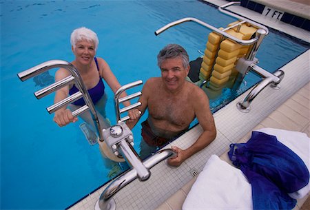 Portrait of Mature Couple in Swimwear with Exercise Equipment In Swimming Pool Foto de stock - Direito Controlado, Número: 700-00075429