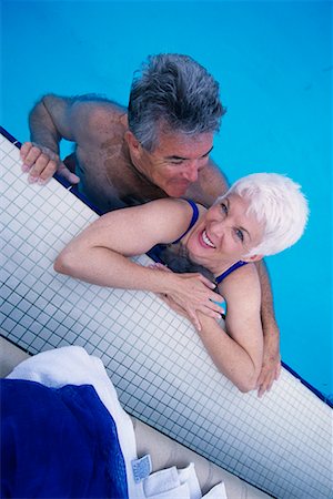 simsearch:700-00056071,k - Couple d'âge mûr en maillot de bain se penchant sur le bord de la piscine Photographie de stock - Rights-Managed, Code: 700-00075432