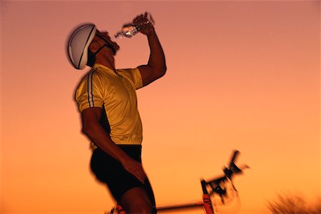 satisfied (thirst) - Man on Mountain Bike, Drinking Water at Sunset Foto de stock - Con derechos protegidos, Código: 700-00075468