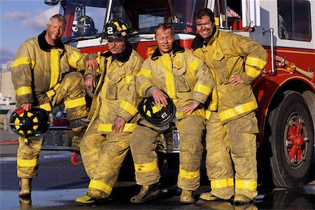 fuliggine - Group Portrait of Male Firefighters Leaning on Fire Engine Fotografie stock - Rights-Managed, Codice: 700-00075555