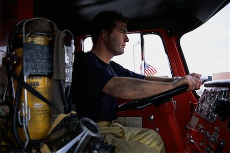 serious truck driver - Male Fire Fighter Driving Fire Truck Stock Photo - Rights-Managed, Code: 700-00076139