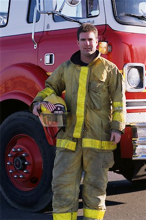 flags on fire trucks pictures - Portrait of Male Firefighter Holding Helmet and American Flag Near Fire Truck Stock Photo - Rights-Managed, Code: 700-00076151