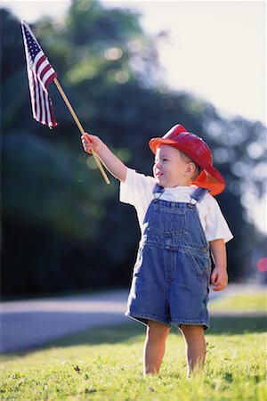 Child Wearing Firefighter's Helmet, Holding American Flag Outdoors Stock Photo - Rights-Managed, Code: 700-00076567