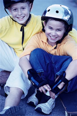 portrait of boy sitting on skateboard - Portrait of Two Boys Wearing Skateboarding Equipment Outdoors Stock Photo - Rights-Managed, Code: 700-00077541