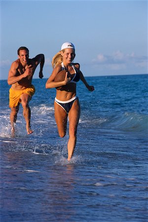 Couple in Swimwear, Running in Surf on Beach with Football Stock Photo - Rights-Managed, Code: 700-00079093