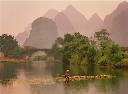 Man Sitting on Rocks in Yulong River by Dragon Bridge, near Yangshuo, Guangxi Region, China Foto de stock - Direito Controlado, Número: 700-00079846