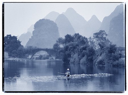 Man Sitting on Rocks in Yulong River by Dragon Bridge, near Yangshuo, Guangxi Region, China Foto de stock - Direito Controlado, Número: 700-00079848