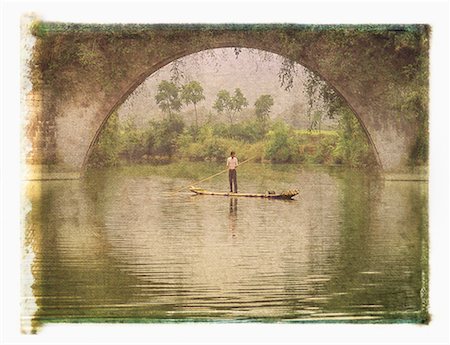 Man in Raft on Yulong River near Dragon Bridge, near Yangshuo Guangxi Region, China Foto de stock - Direito Controlado, Número: 700-00079849