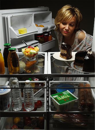 Woman Looking at Fruit Salad in Fridge with Chocolate Cake, Tofu And Juice Stock Photo - Rights-Managed, Code: 700-00079958