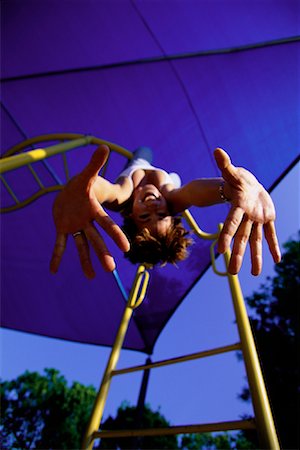 Portrait of Woman Hanging Upside Down from Monkey Bars Stock Photo - Rights-Managed, Code: 700-00070037