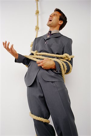 Businessman Tied with Knotted Rope, Yelling Stock Photo - Rights-Managed, Code: 700-00070814