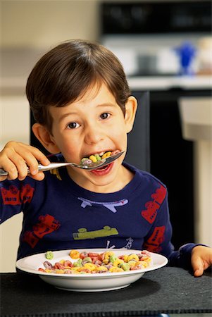 Portrait of Boy in Pyjamas Eating Cereal at Table Stock Photo - Rights-Managed, Code: 700-00070921